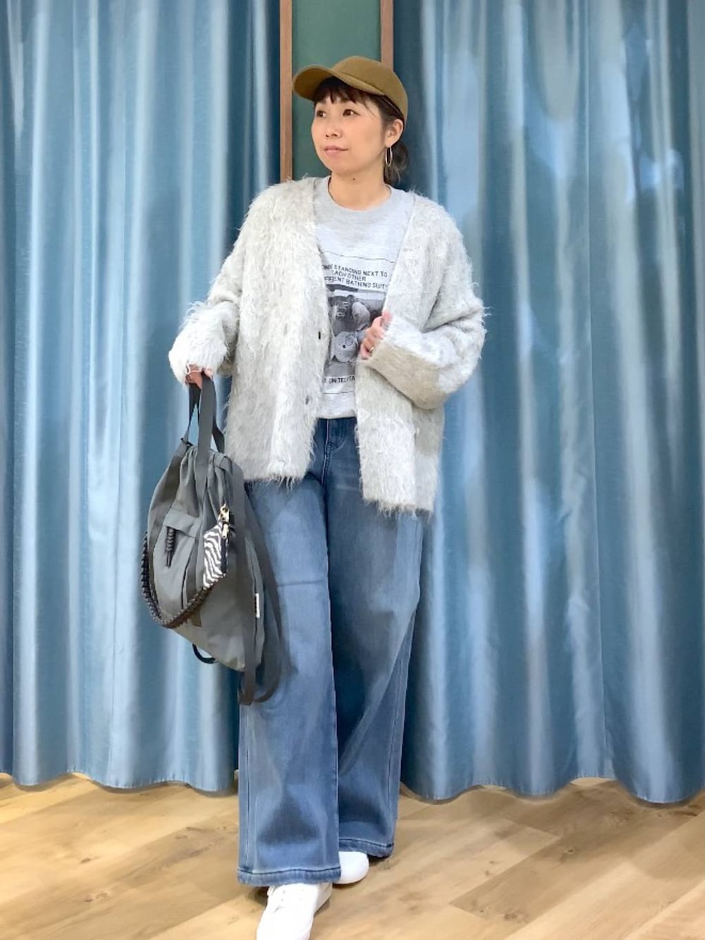 ブルー系のデニムパンツ、グレー系のTシャツ/カットソー、グレー系のバックパック/リュックを着用したレディースの秋コーディネートの1枚目の写真