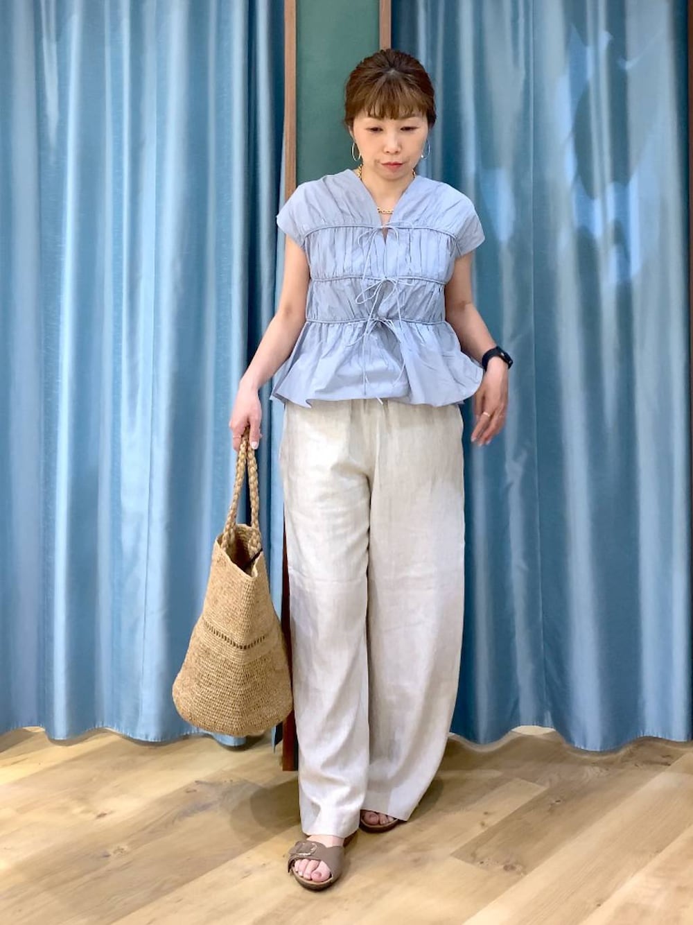 ホワイト系のタンクトップ、ベージュ系のその他パンツ、ブルー系のシャツ/ブラウスを着用したレディースの春コーディネートの1枚目の写真