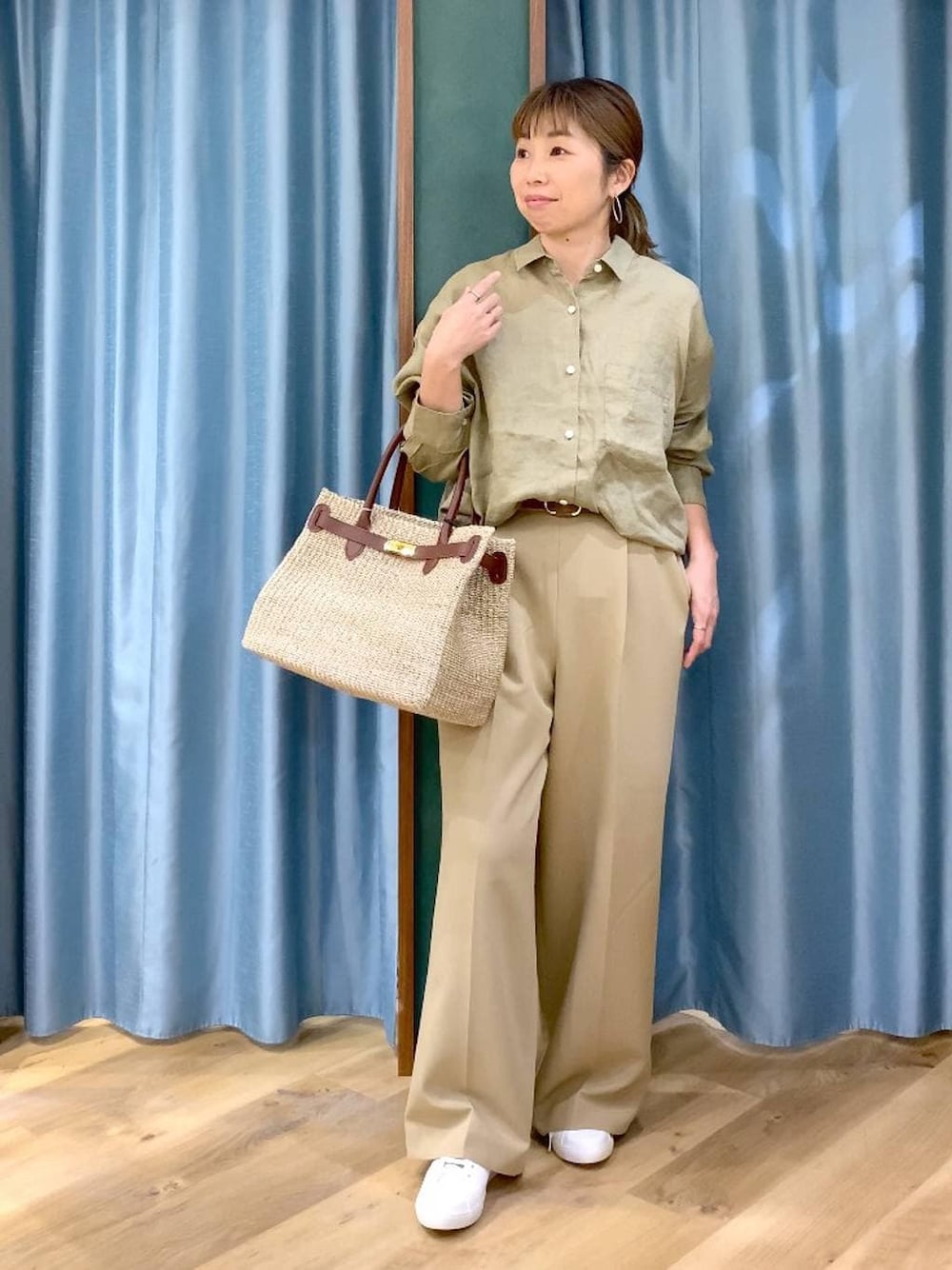 ベージュ系のシャツ/ブラウス、ブラウン系のスニーカー、ベージュ系のかごバッグを着用したレディースの春コーディネートの1枚目の写真