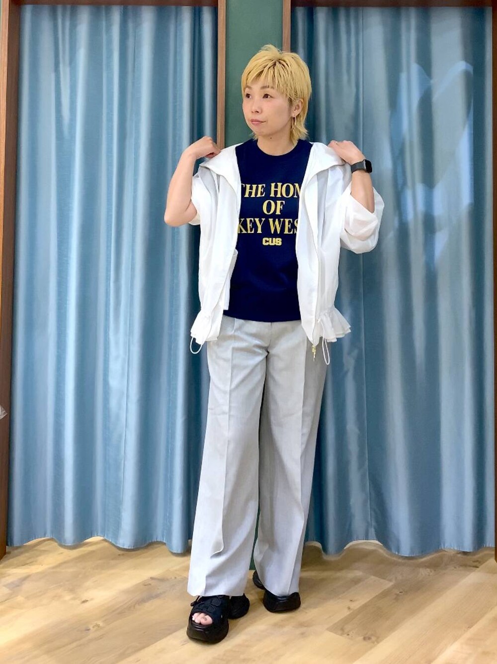 ブルー系のTシャツ/カットソー、ブラック系のサンダル、ホワイト系のブルゾンを着用したレディースの夏コーディネートの1枚目の写真