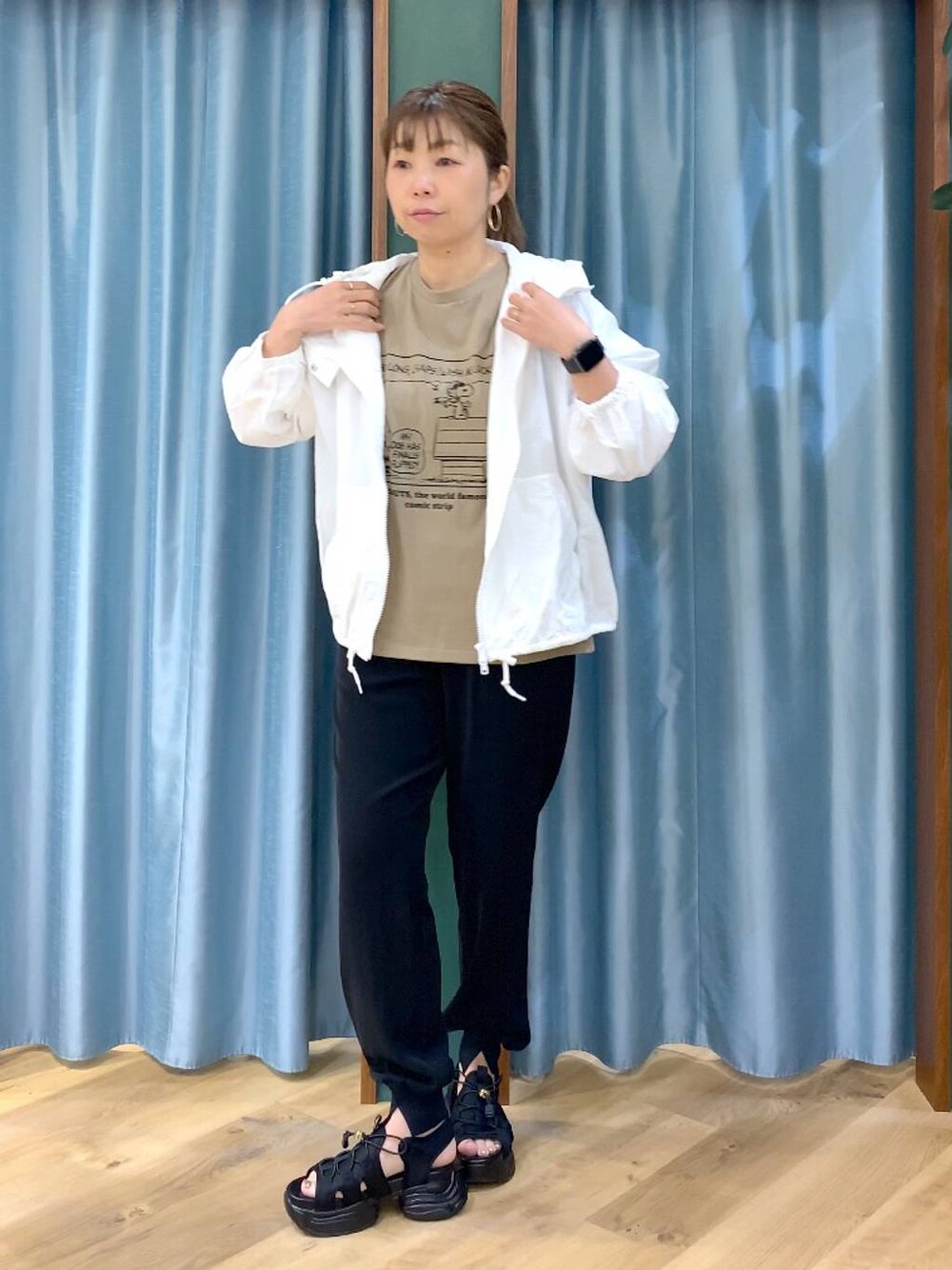 ホワイト系のブルゾン、ベージュ系のTシャツ/カットソー、ブラック系のサンダルを着用したレディースの春コーディネートの1枚目の写真