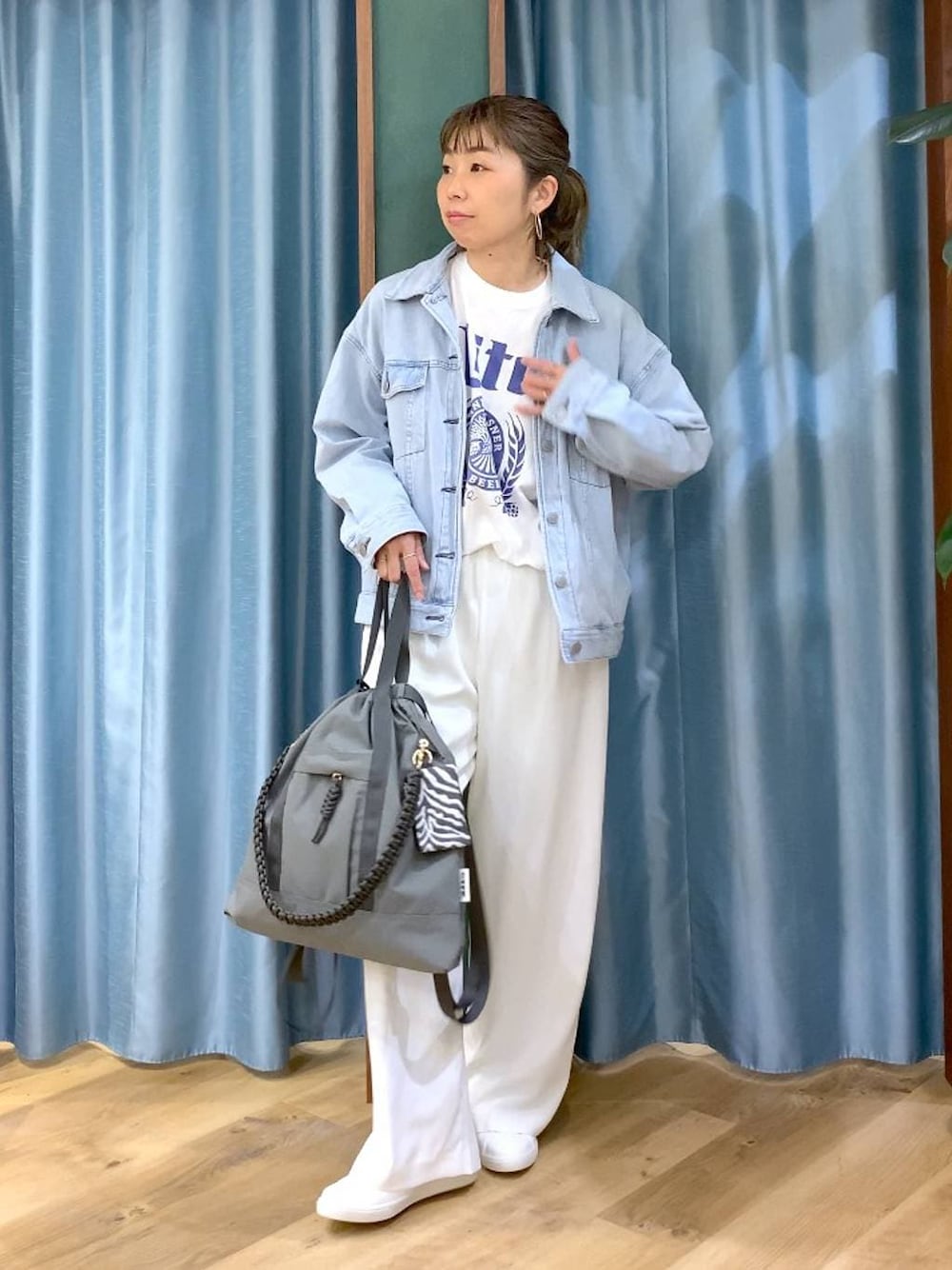 ホワイト系のスラックス、ブルー系のデニムジャケット、ホワイト系のTシャツ/カットソーを着用したレディースの冬コーディネートの1枚目の写真