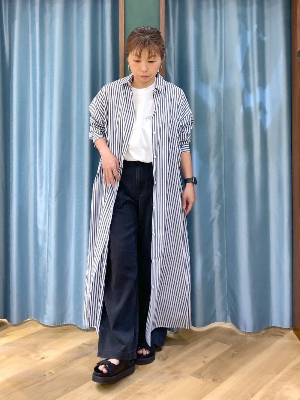 ホワイト系のTシャツ/カットソー、ブルー系のワンピース、グレー系のデニムパンツを着用したレディースの春コーディネートの1枚目の写真