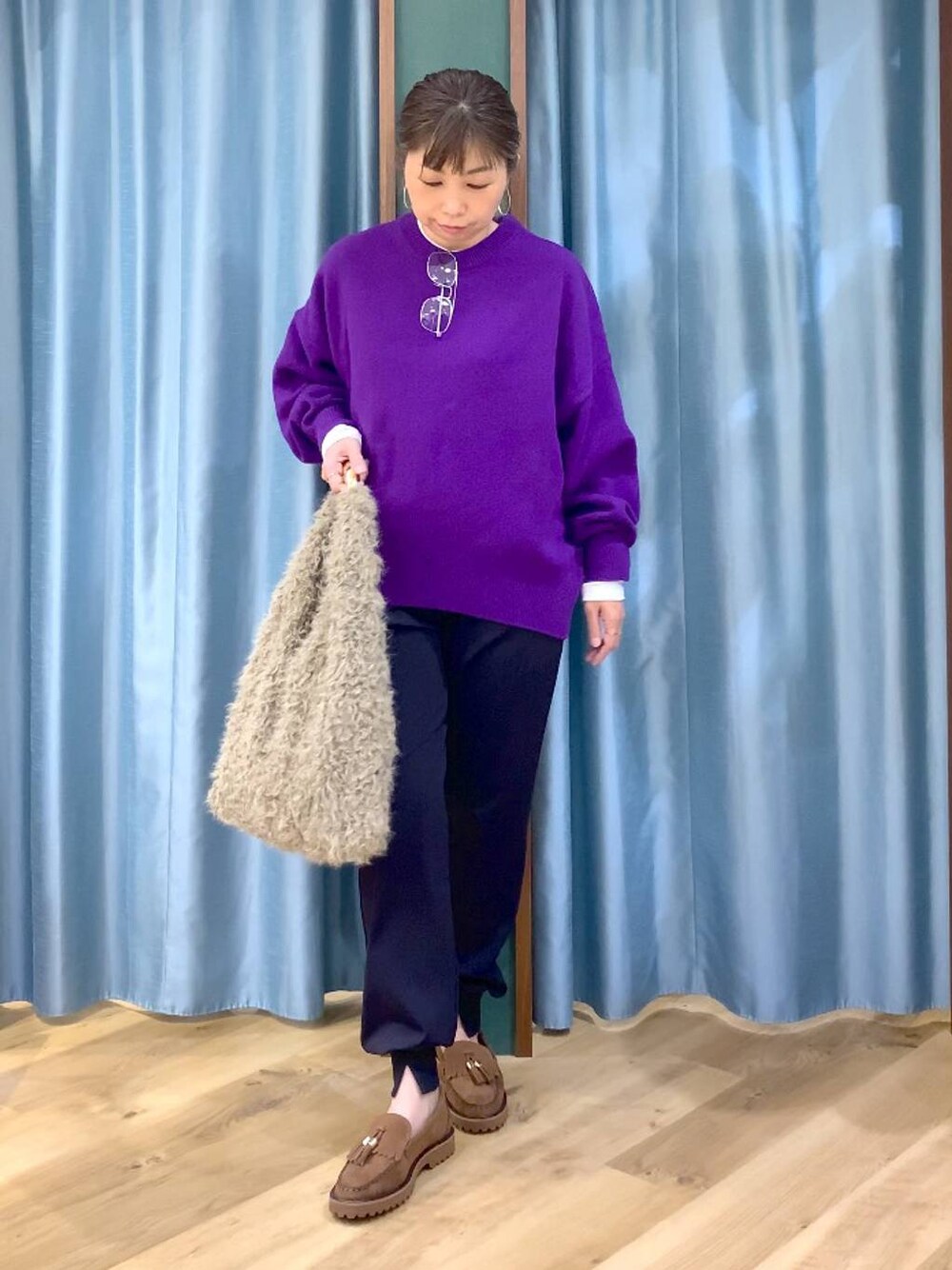 パープル系のニット/セーター、ベージュ系のハンドバッグ、ブルー系のその他パンツを着用したレディースの秋コーディネートの1枚目の写真