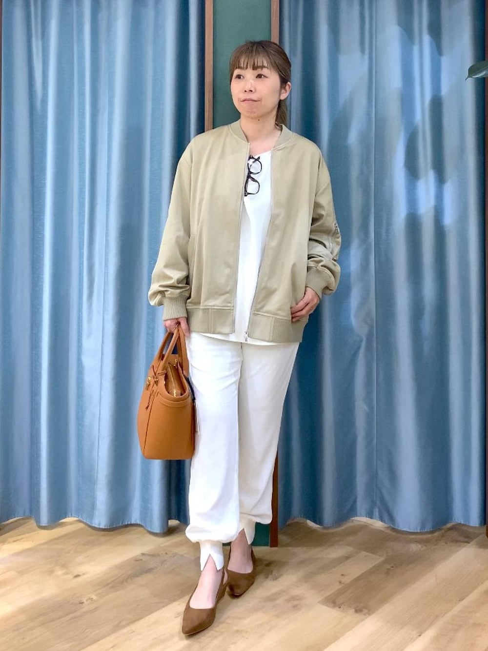 ベージュ系のMA-1、ホワイト系のTシャツ/カットソー、イエロー系のハンドバッグを着用したレディースの冬コーディネートの1枚目の写真