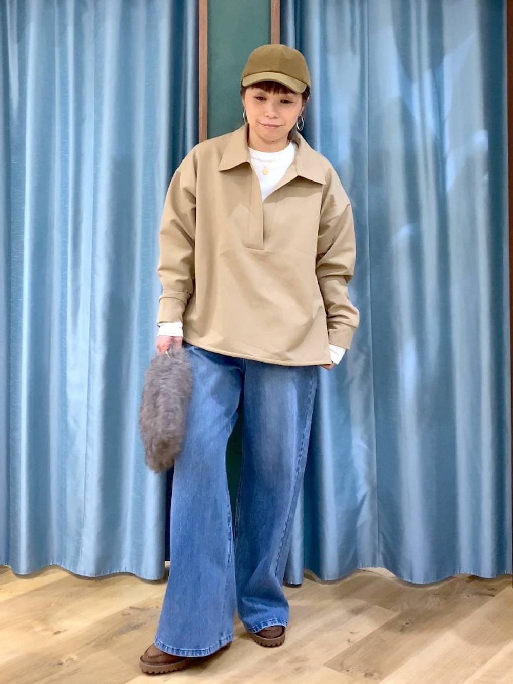 ブルー系のデニムパンツ、ブラウン系のトートバッグ、ブラウン系のローファーを着用したレディースの冬コーディネートの1枚目の写真