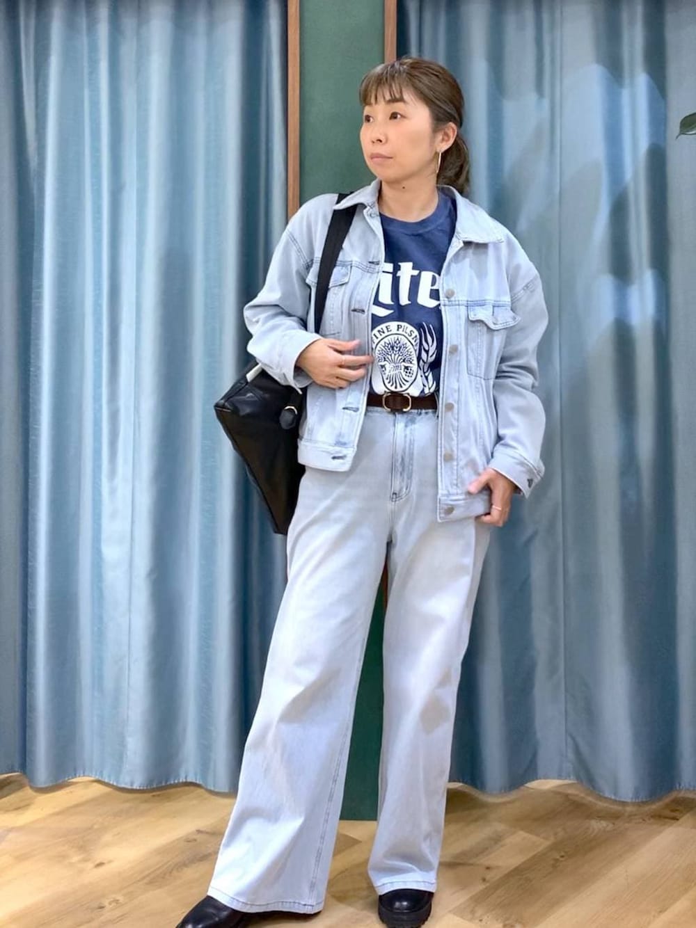 ブラック系のブーツ、ブラック系のバックパック/リュック、ブルー系のデニムパンツを着用したレディースの冬コーディネートの1枚目の写真