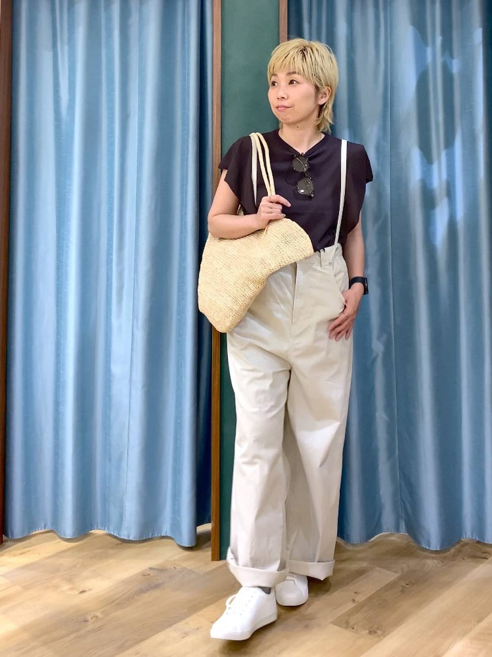 ベージュ系のその他パンツ、ブラウン系のニット/セーター、ベージュ系のかごバッグを着用したレディースの春コーディネートの1枚目の写真