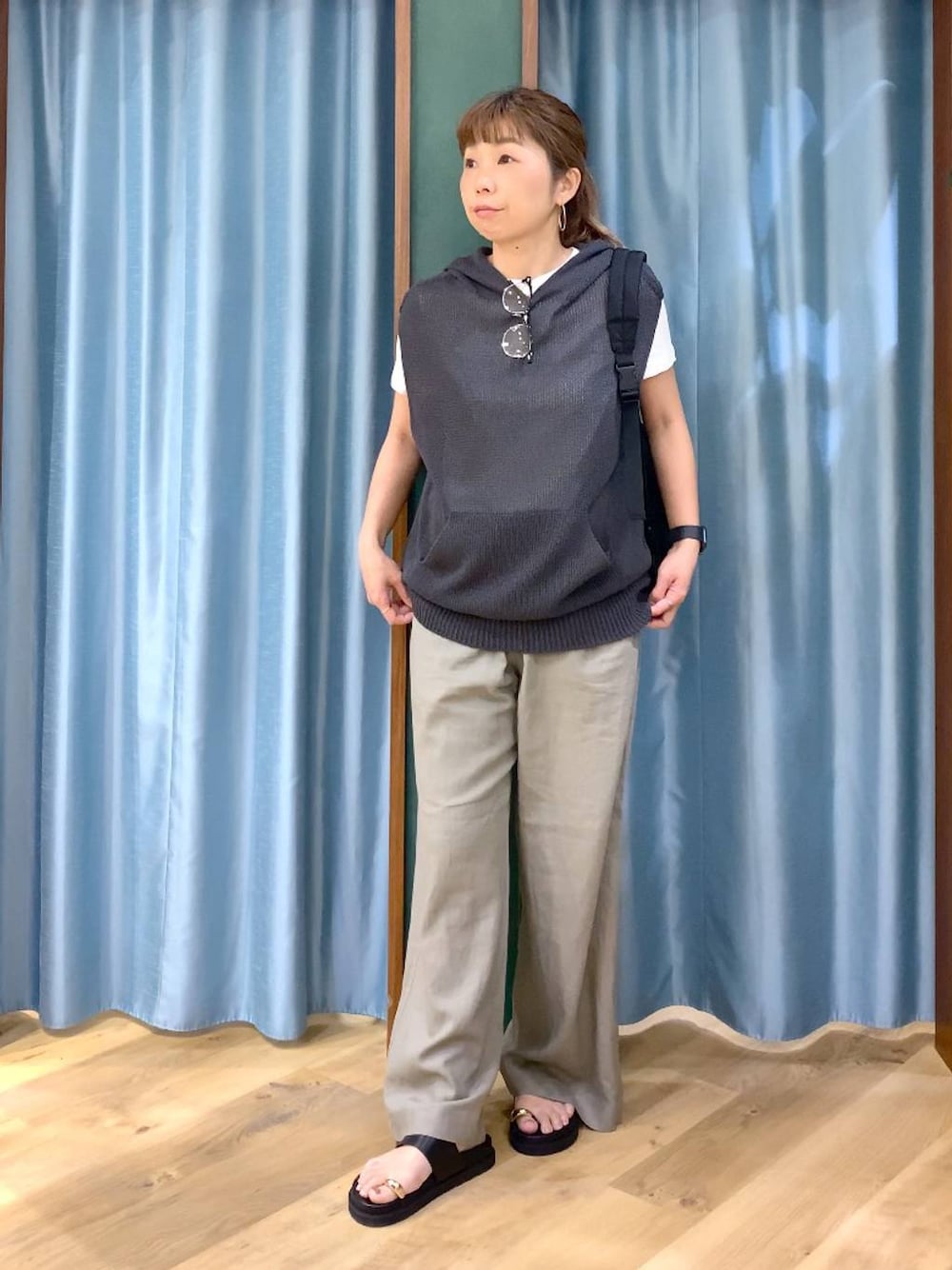 グレー系のニット/セーター、ブラウン系のその他パンツ、ブラック系のサンダルを着用したレディースの春コーディネートの1枚目の写真