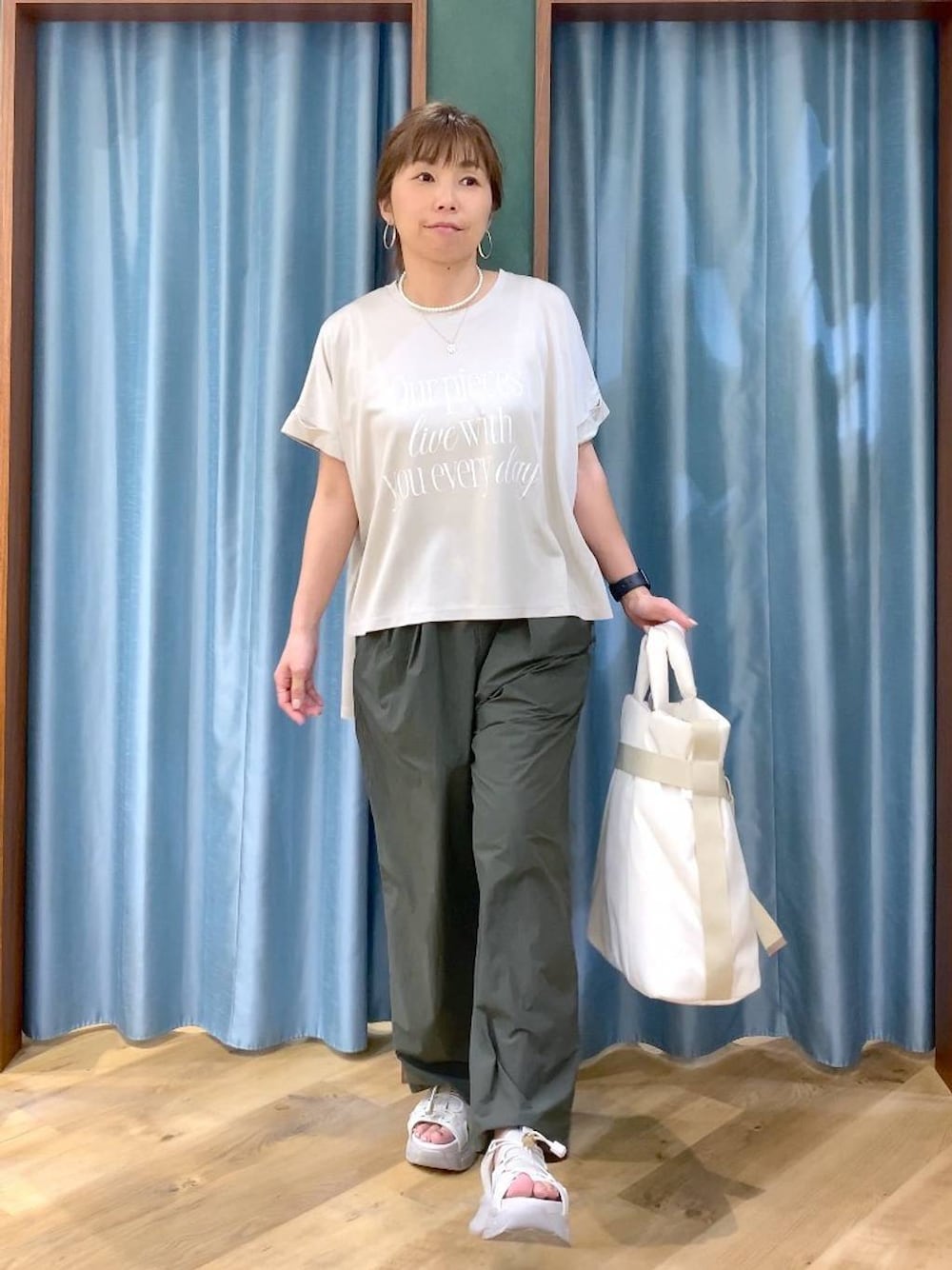 グリーン系のその他パンツ、ホワイト系のトートバッグ、グレー系のサンダルを着用したレディースの春コーディネートの1枚目の写真