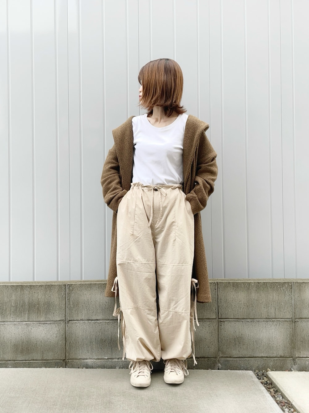ベージュ系のカーゴパンツ、ベージュ系のスニーカー、ブラウン系のジャケット/アウターを着用したレディースの冬コーディネートの1枚目の写真