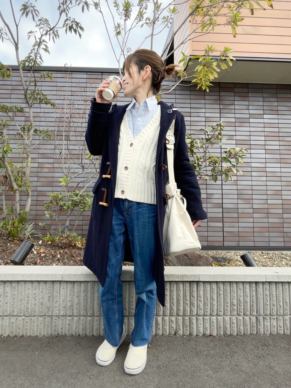 ブルー系のデニムパンツ、ホワイト系のカーディガン/ボレロ、ブルー系のシャツ/ブラウスを着用したレディースの冬コーディネートの1枚目の写真