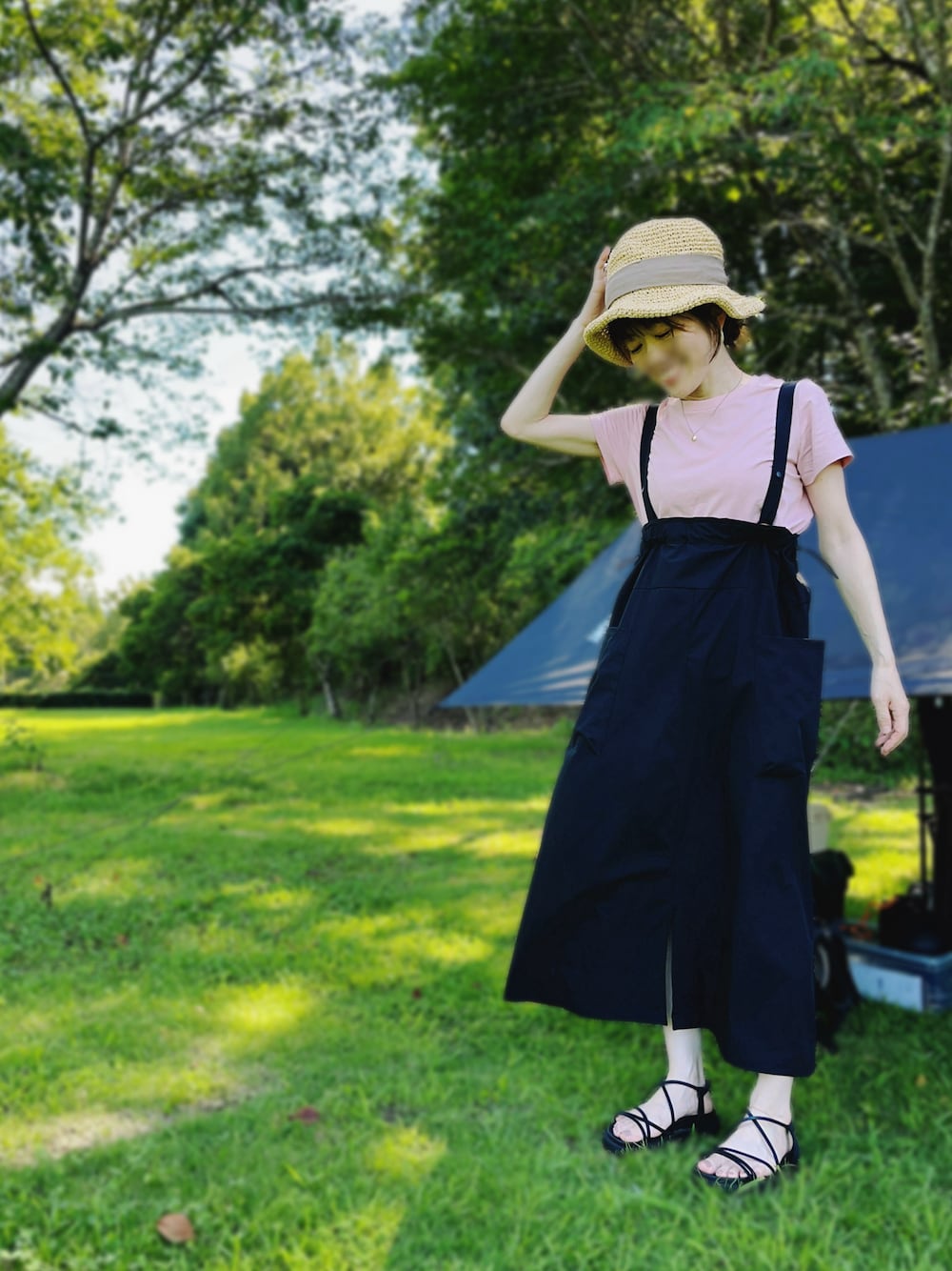 ブラック系のサンダル、ブラック系のジャンパースカート、ピンク系のTシャツ/カットソーを着用したレディースの夏コーディネートの1枚目の写真