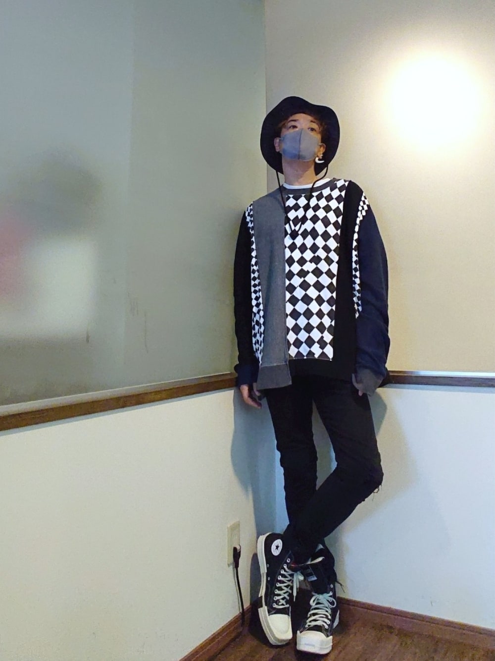 グレー系のスウェット、ブラック系のデニムパンツ、ブラック系のスニーカーを着用したメンズの春コーディネートの1枚目の写真