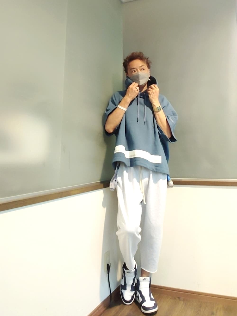 ブルー系のパーカー、グレー系のスウェットパンツ、ホワイト系のスニーカーを着用したメンズの秋コーディネートの1枚目の写真