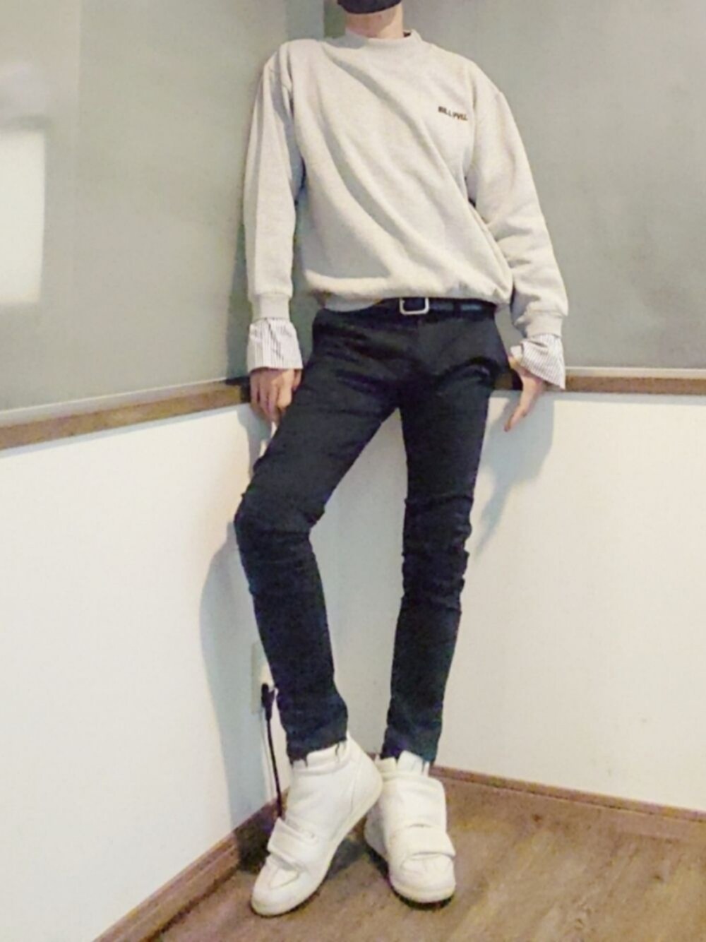 グレー系のスウェット、ブラック系のデニムパンツ、ホワイト系のスニーカーを着用したメンズの秋コーディネートの1枚目の写真