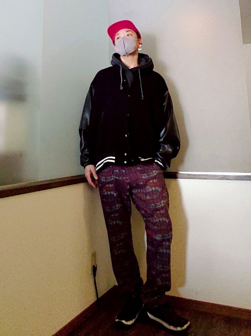 ブラック系のスタジャン、ブラック系のパーカー、レッド系のパンツを着用したメンズの冬コーディネートの2枚目の写真