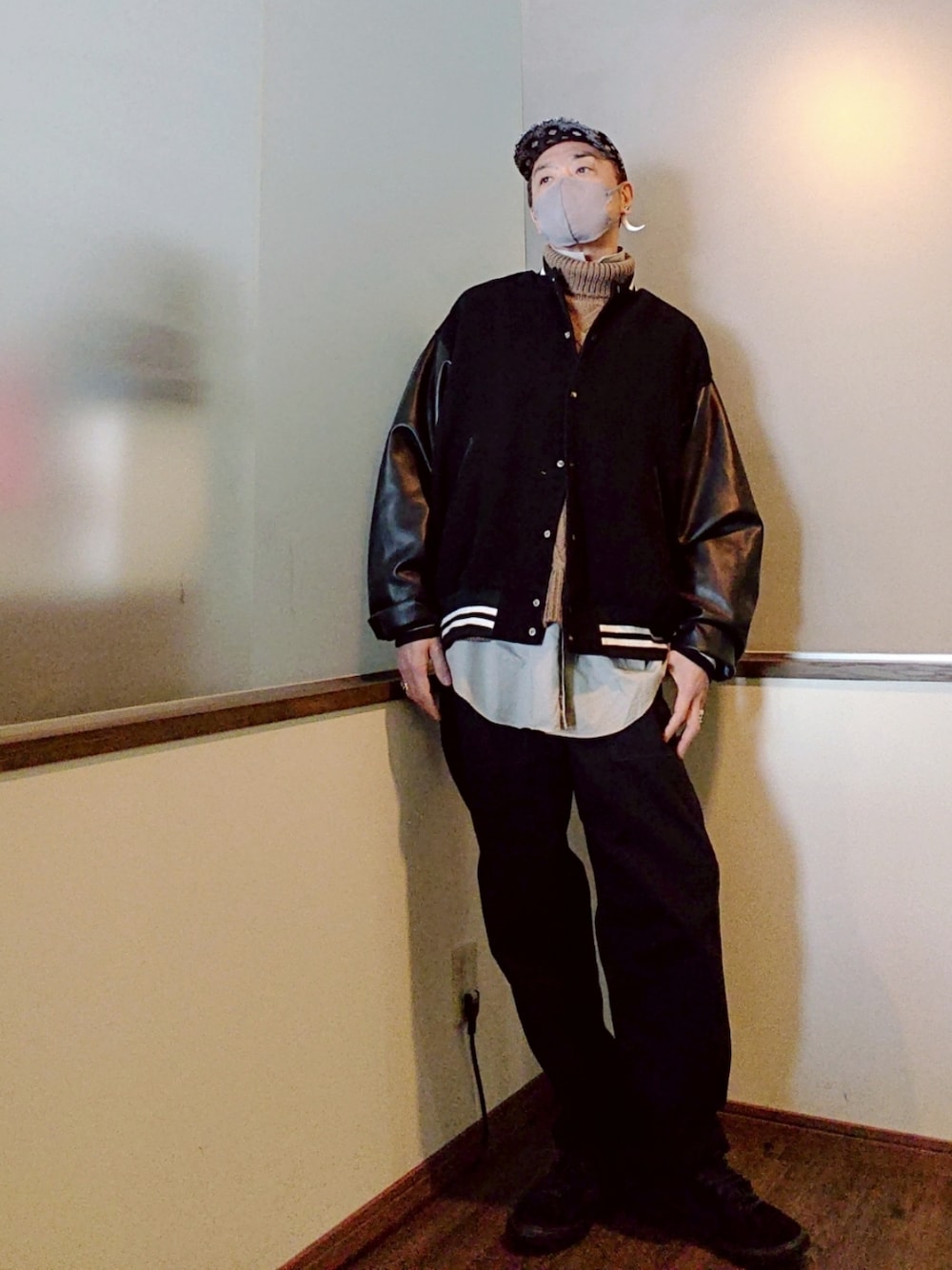 ブラック系のスタジャン、ベージュ系のニット/セーター、グレー系のシャツ/ブラウスを着用したメンズの冬コーディネートの3枚目の写真