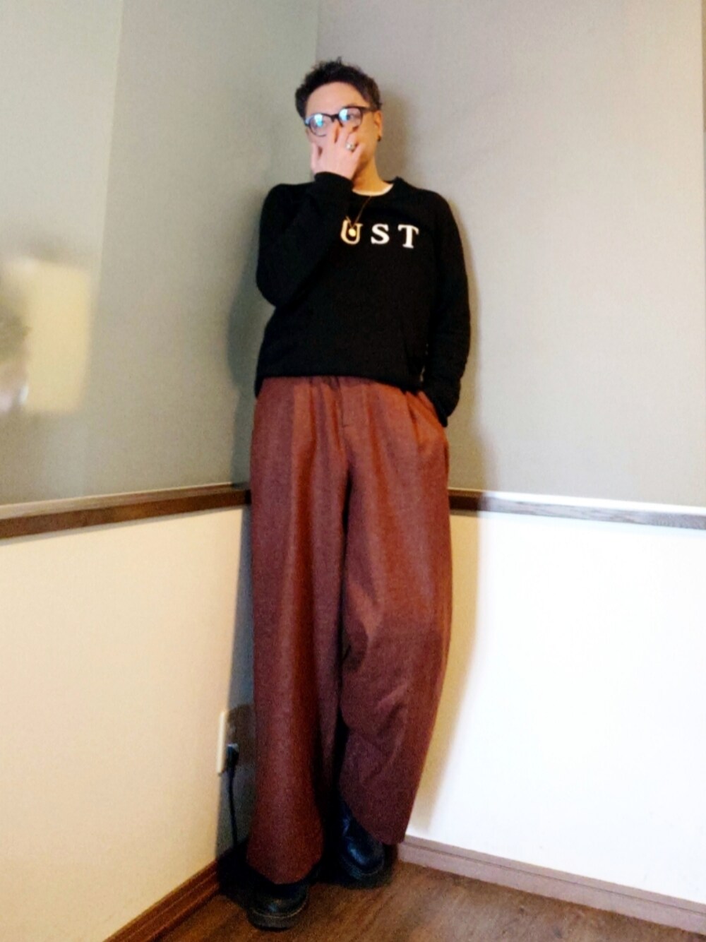 ブラウン系のパンツ、ブラック系のドレスシューズ、ブラック系のスウェットを着用したメンズの春コーディネートの1枚目の写真