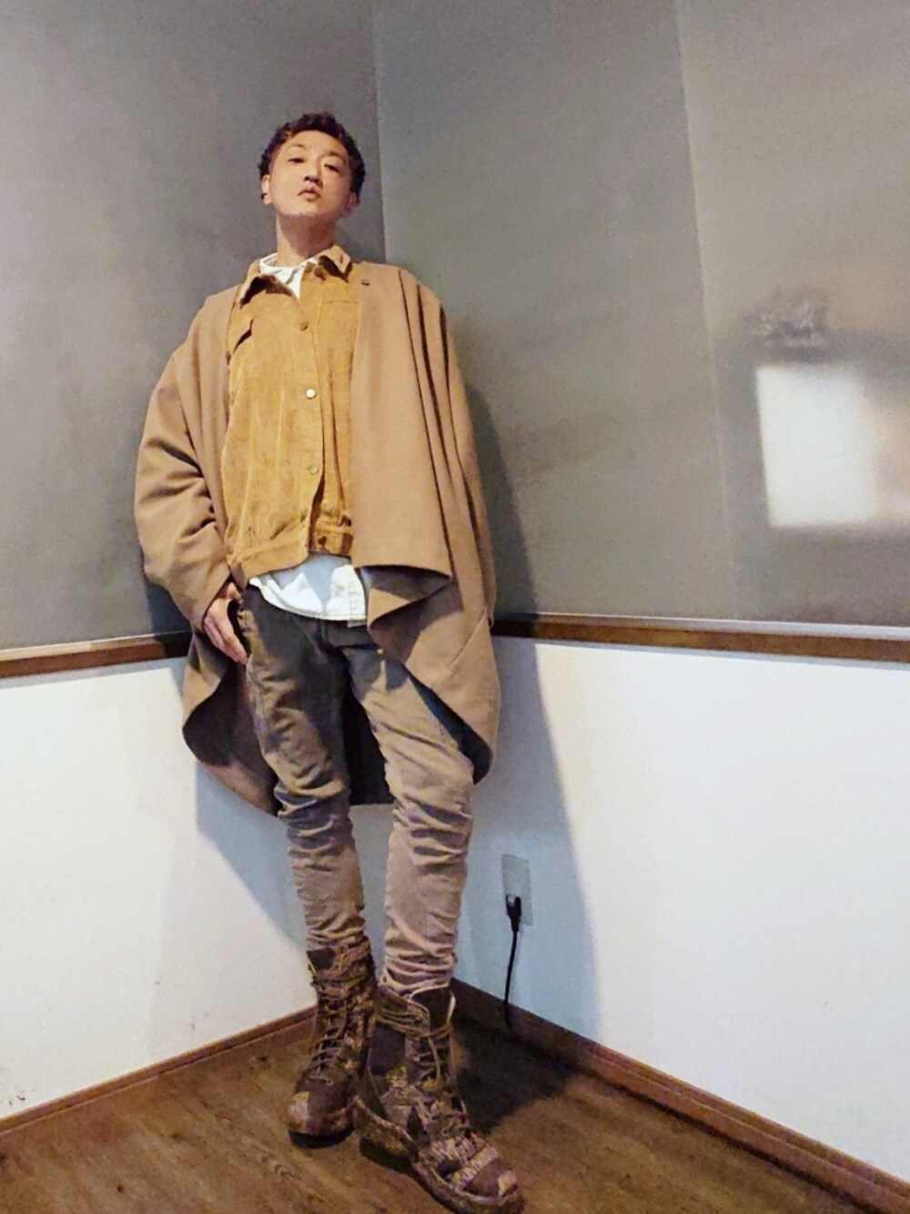 ブラウン系のポンチョ、ベージュ系のブルゾン、ブラウン系のデニムパンツを着用したメンズの秋コーディネートの1枚目の写真