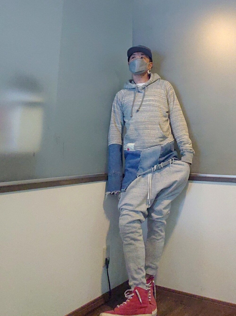 グレー系のパーカー、グリーン系のトレンチコート、グレー系のスウェットパンツを着用したメンズの春コーディネートの2枚目の写真