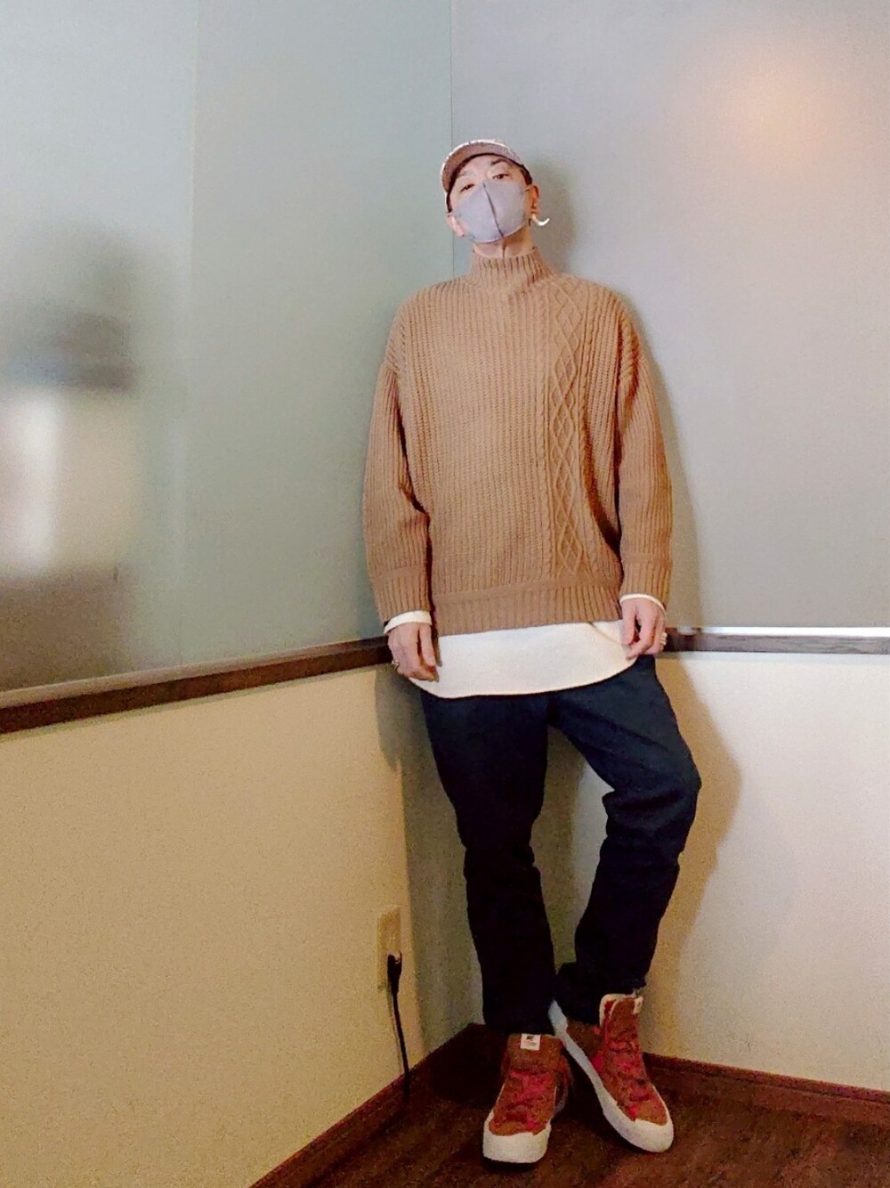 ベージュ系のチェスターコート、ベージュ系のニット/セーター、ブルー系のパンツを着用したメンズの冬コーディネートの2枚目の写真