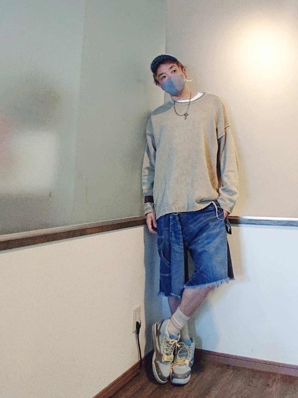 ベージュ系のニット/セーター、ブルー系のデニムパンツ、ブルー系のスニーカーを着用したメンズの夏コーディネートの1枚目の写真