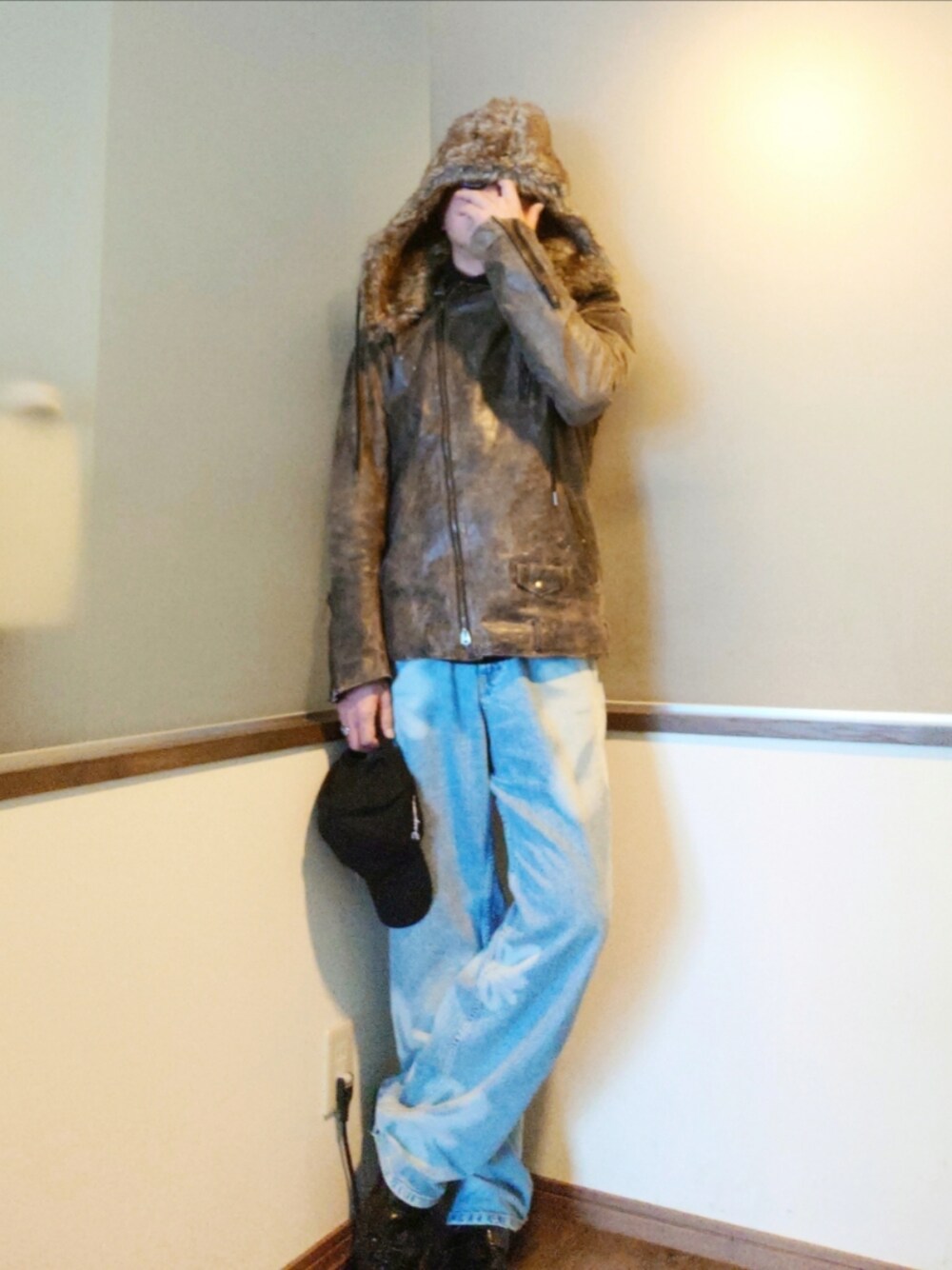 ブラウン系のライダースジャケット、ブルー系のデニムパンツ、ブラック系のローファーを着用したメンズの冬コーディネートの1枚目の写真