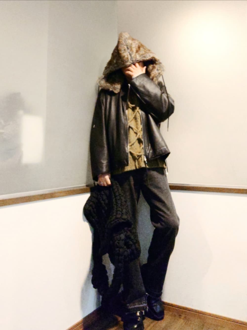 ブラック系のブルゾン、グリーン系のニット/セーター、ブラック系のショルダーバッグを着用したメンズの冬コーディネートの1枚目の写真