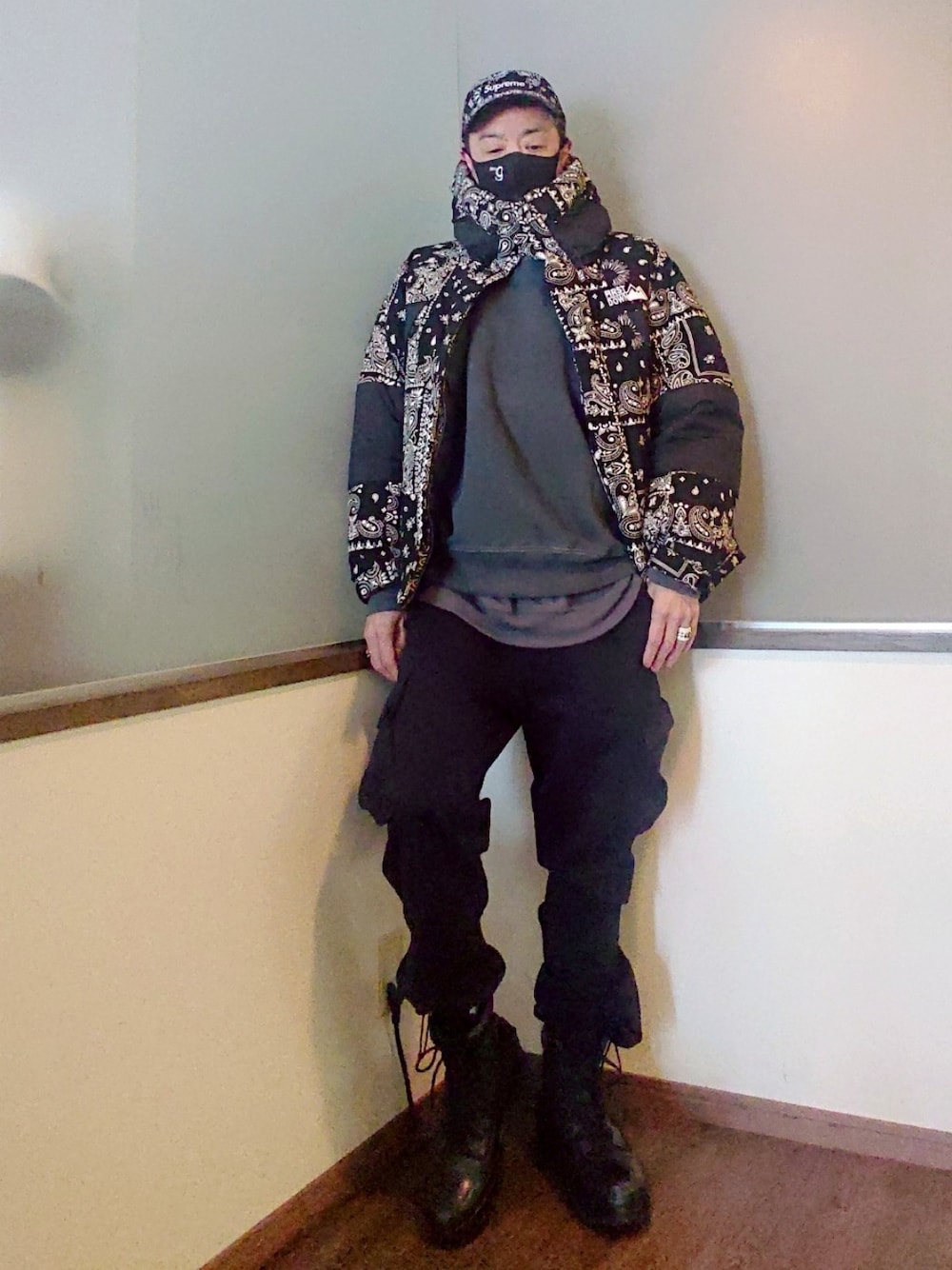 ブラック系のダウンジャケット/コート、グレー系のスウェット、ブラック系のカーゴパンツを着用したメンズの冬コーディネートの2枚目の写真