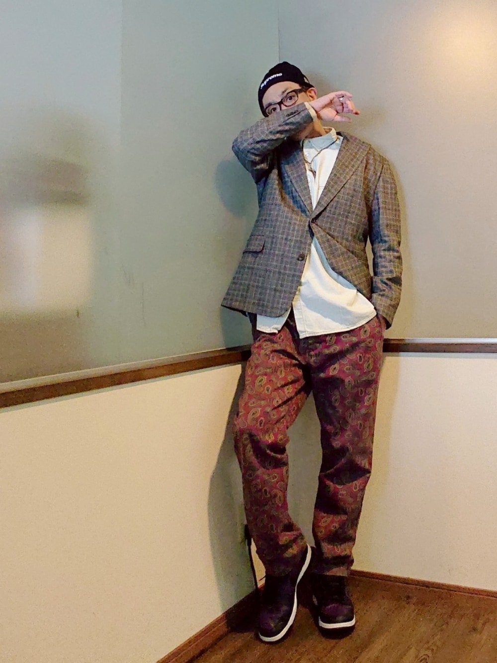 グレー系のテーラードジャケット、レッド系のチノパンツ、パープル系のスニーカーを着用したメンズの冬コーディネートの2枚目の写真