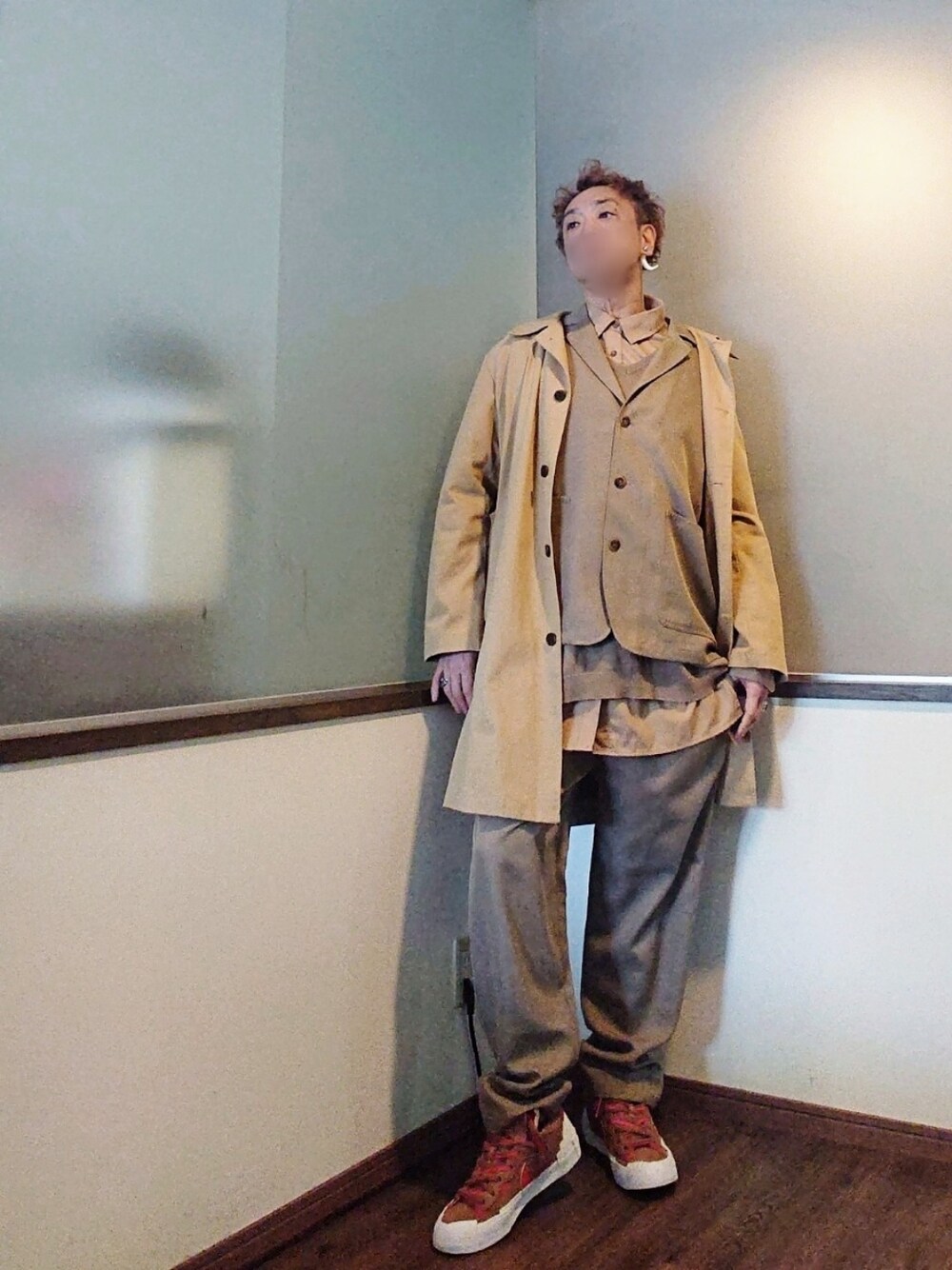 ベージュ系のテーラードジャケット、ベージュ系のステンカラーコート、ベージュ系のベストを着用したメンズの春コーディネートの3枚目の写真