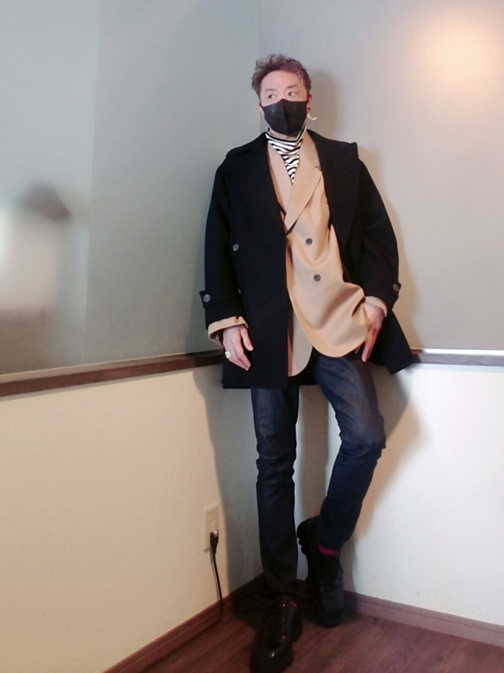 ブラック系のピーコート、ブルー系のデニムパンツ、ブラック系のドレスシューズを着用したメンズの冬コーディネートの1枚目の写真