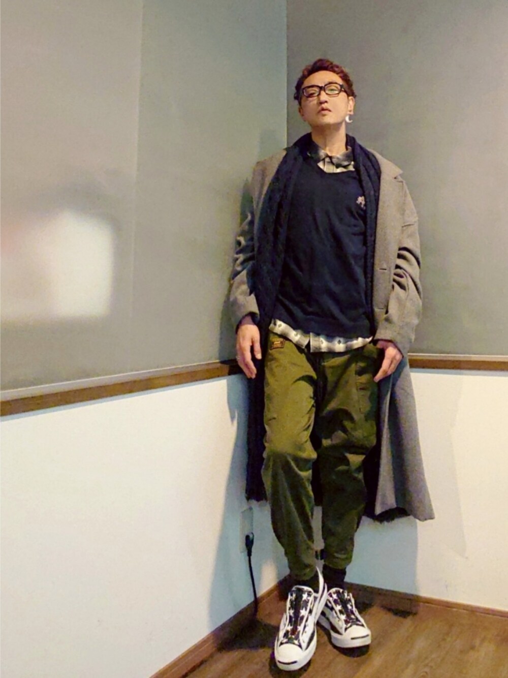 ブルー系のニット/セーター、グレー系のチェスターコート、ブラック系のシャツ/ブラウスを着用したメンズの冬コーディネートの1枚目の写真