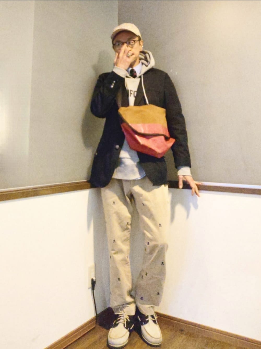 ピンク系のメッセンジャーバッグ、ブルー系のテーラードジャケット、グレー系のパーカーを着用したメンズの春コーディネートの1枚目の写真