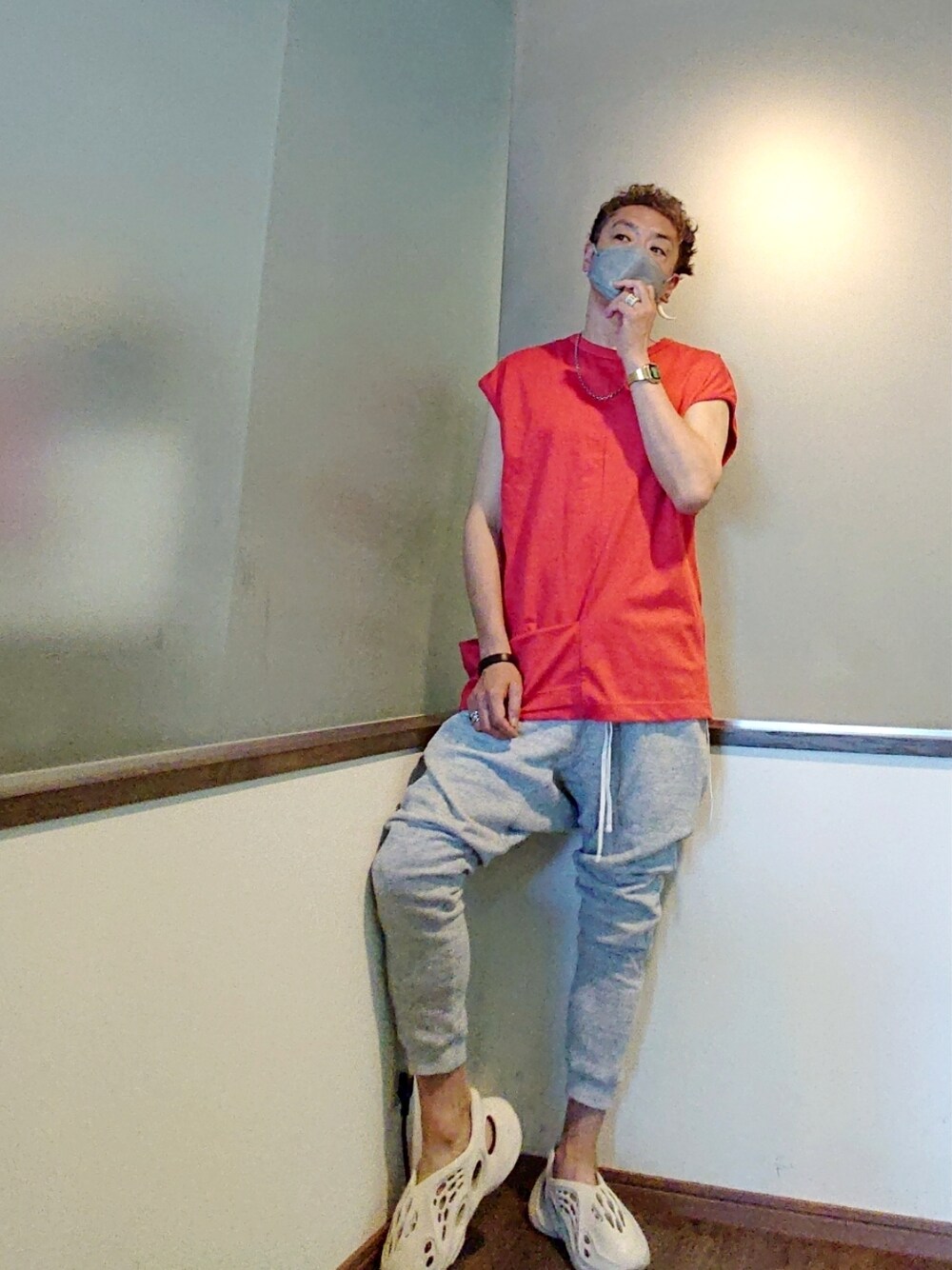 レッド系のTシャツ/カットソー、グレー系のスウェットパンツ、ホワイト系のスニーカーを着用したメンズの夏コーディネートの1枚目の写真