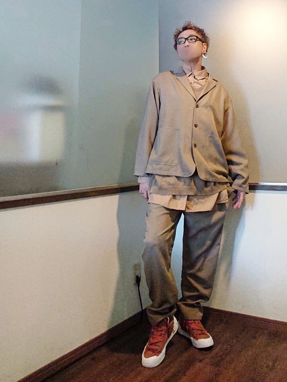 ベージュ系のテーラードジャケット、ベージュ系のステンカラーコート、ベージュ系のベストを着用したメンズの春コーディネートの2枚目の写真