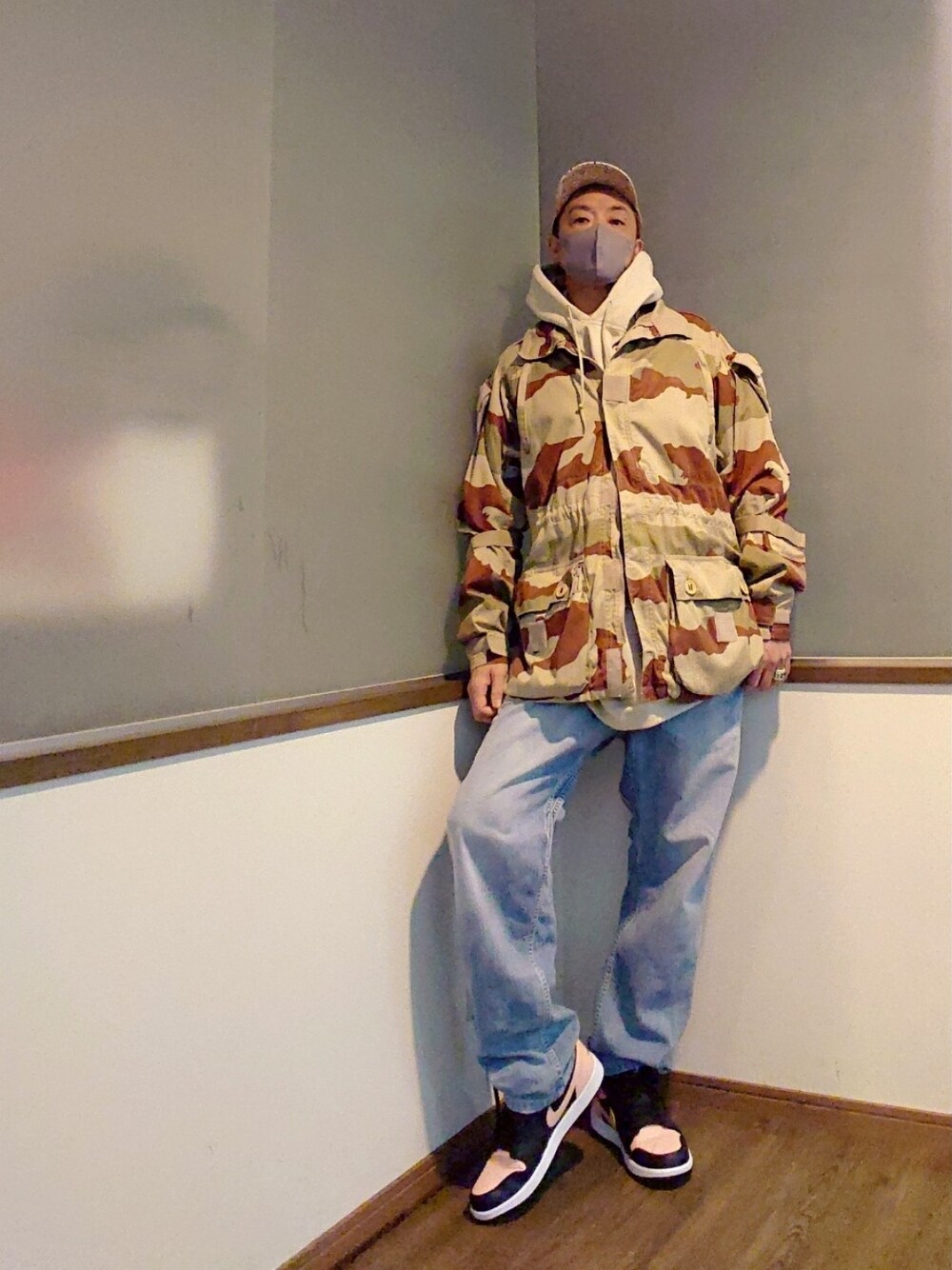 ベージュ系のミリタリージャケット、ブラウン系のベスト、ベージュ系のパーカーを着用したメンズの春コーディネートの4枚目の写真