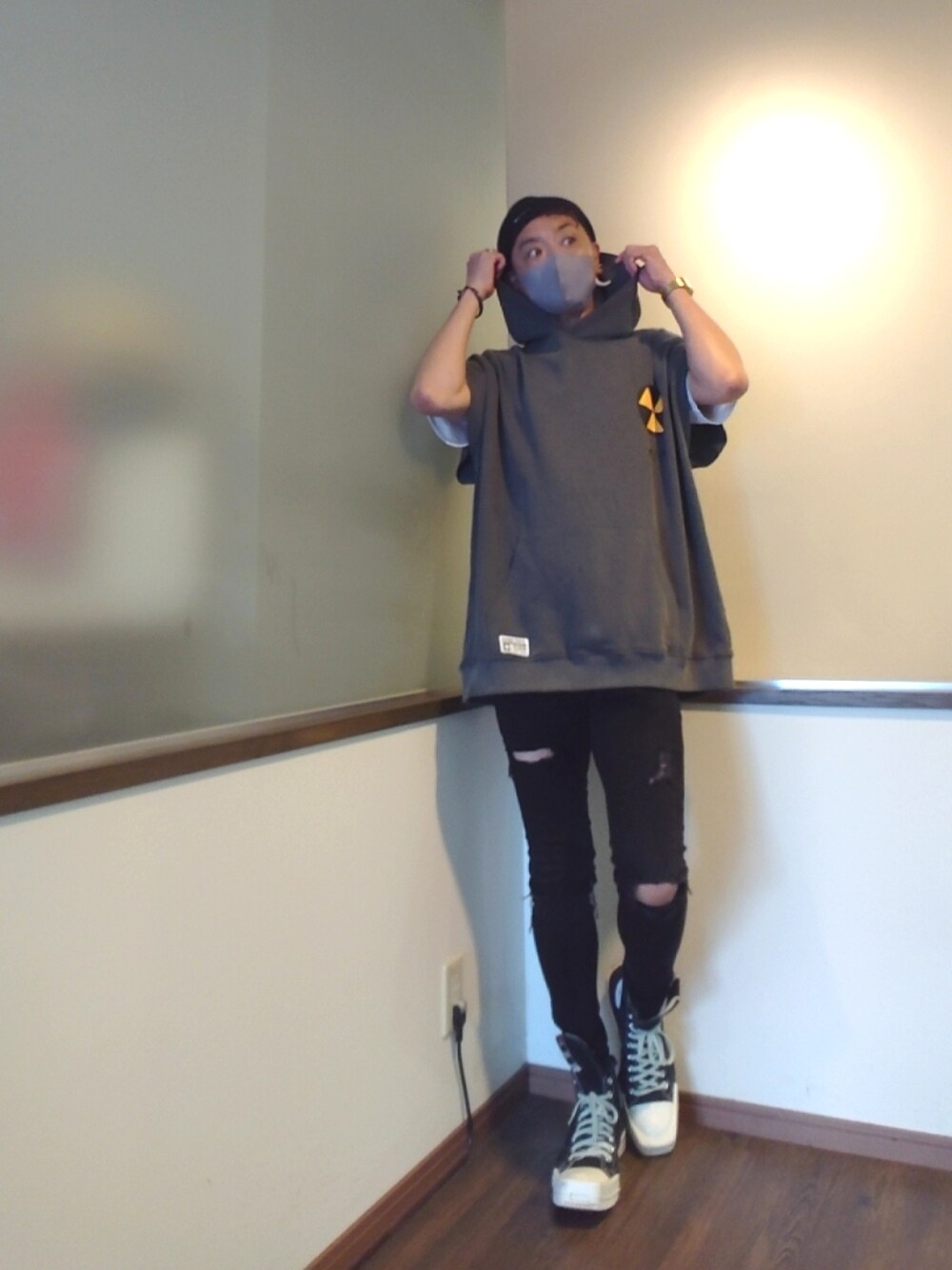 グレー系のパーカー、ブラック系のデニムパンツ、ブラック系のスニーカーを着用したメンズの夏コーディネートの1枚目の写真