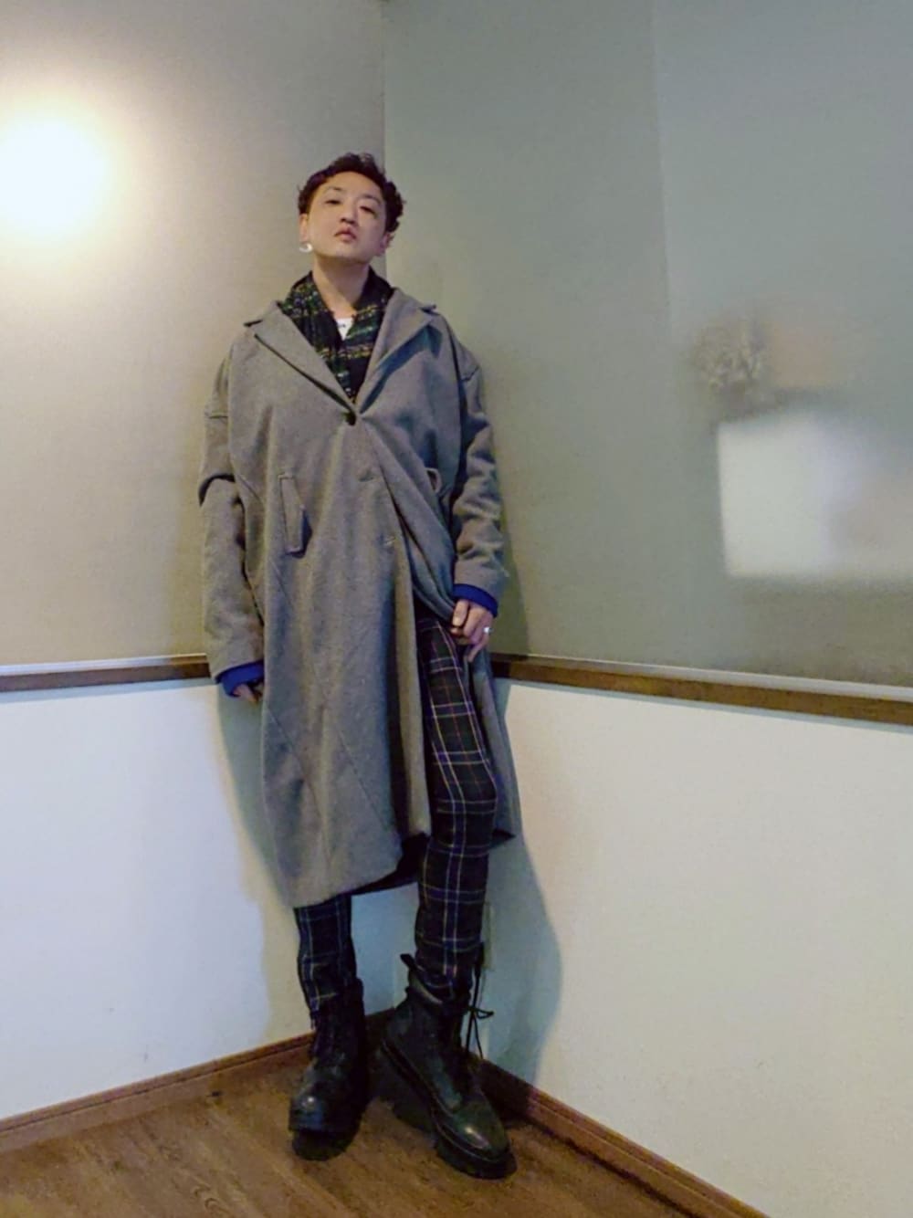 グレー系のチェスターコート、グリーン系のその他パンツ、ブラック系のスニーカーを着用したメンズの秋コーディネートの1枚目の写真