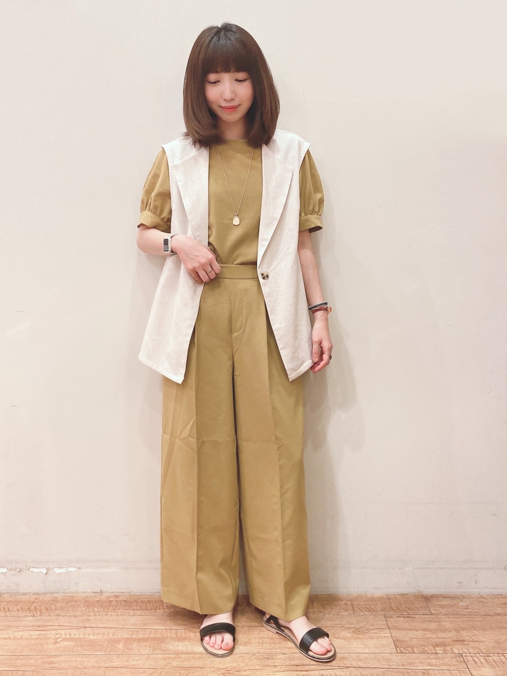 イエロー系のシャツ/ブラウス、イエロー系のその他パンツ、ベージュ系のベストを着用したレディースの春コーディネートの1枚目の写真