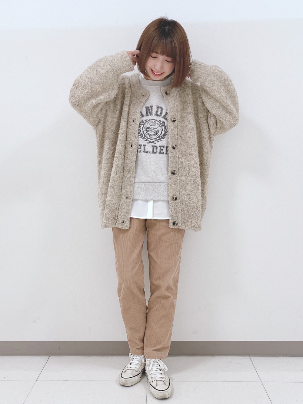 ベージュ系のカーディガン/ボレロ、グレー系のスウェット、ホワイト系のシャツ/ブラウスを着用したレディースの秋コーディネートの1枚目の写真