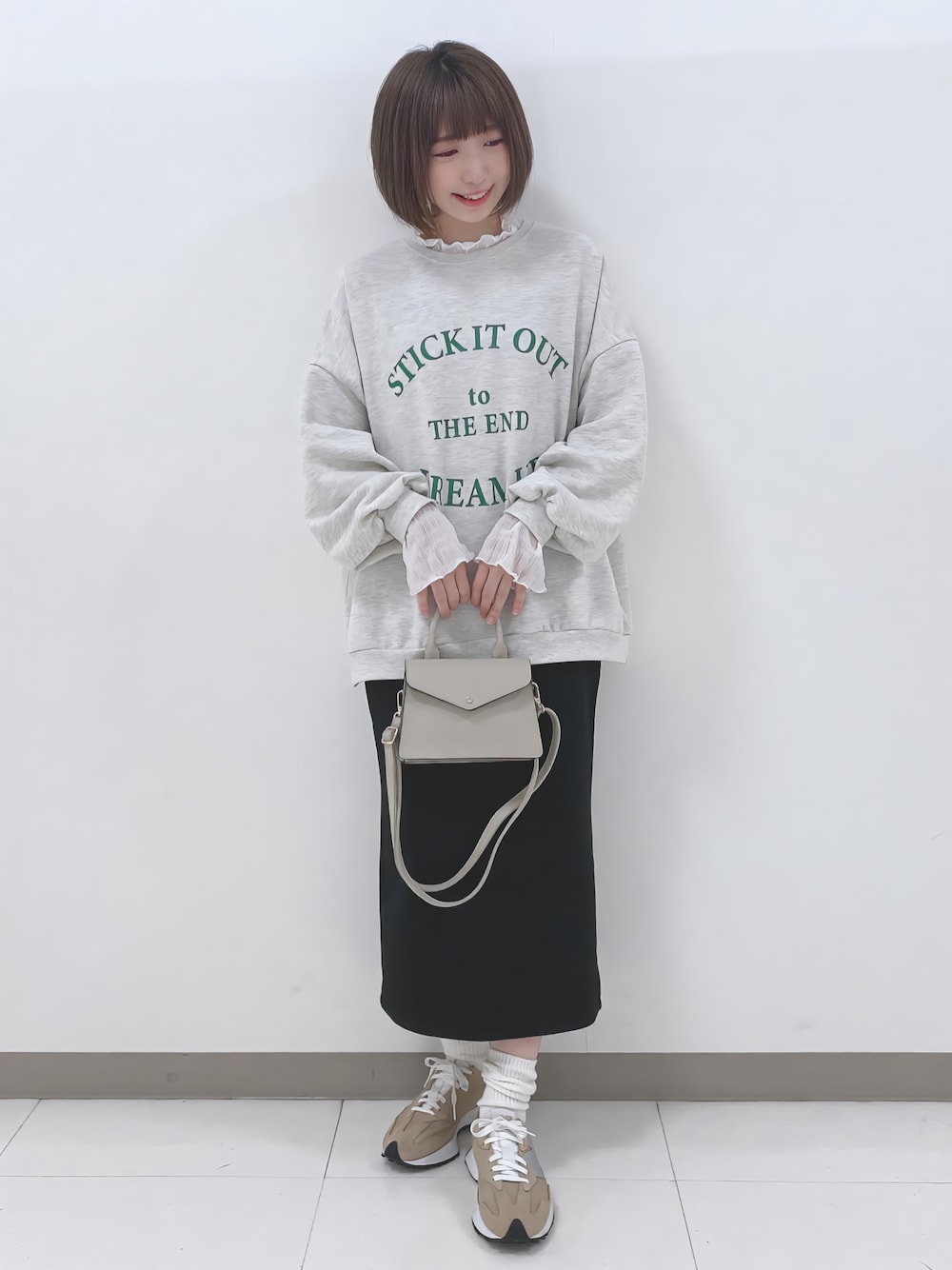 グレー系のスウェット、ホワイト系のTシャツ/カットソー、ブラック系のスカートを着用したレディースの秋コーディネートの1枚目の写真