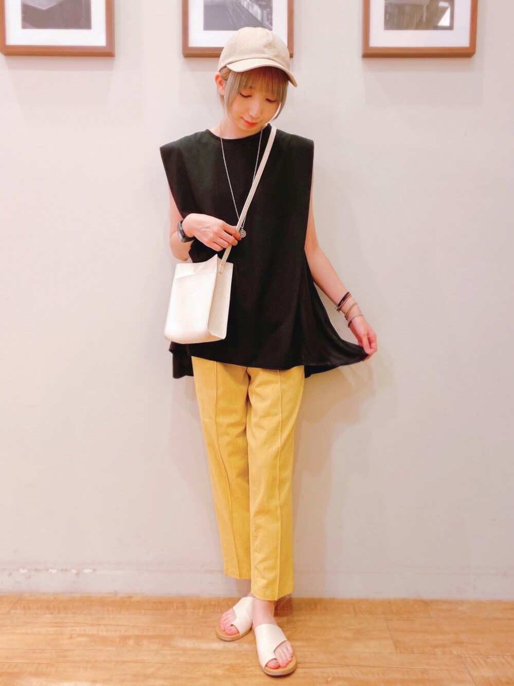 イエロー系のその他パンツ、ブラック系のTシャツ/カットソー、ホワイト系のサンダルを着用したレディースの夏コーディネートの1枚目の写真