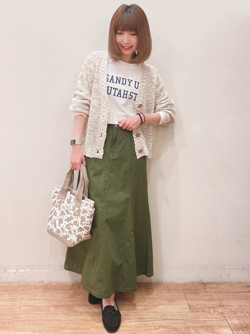 ホワイト系のTシャツ/カットソー、ベージュ系のカーディガン/ボレロ、ブラック系のその他シューズを着用したレディースの春コーディネートの1枚目の写真