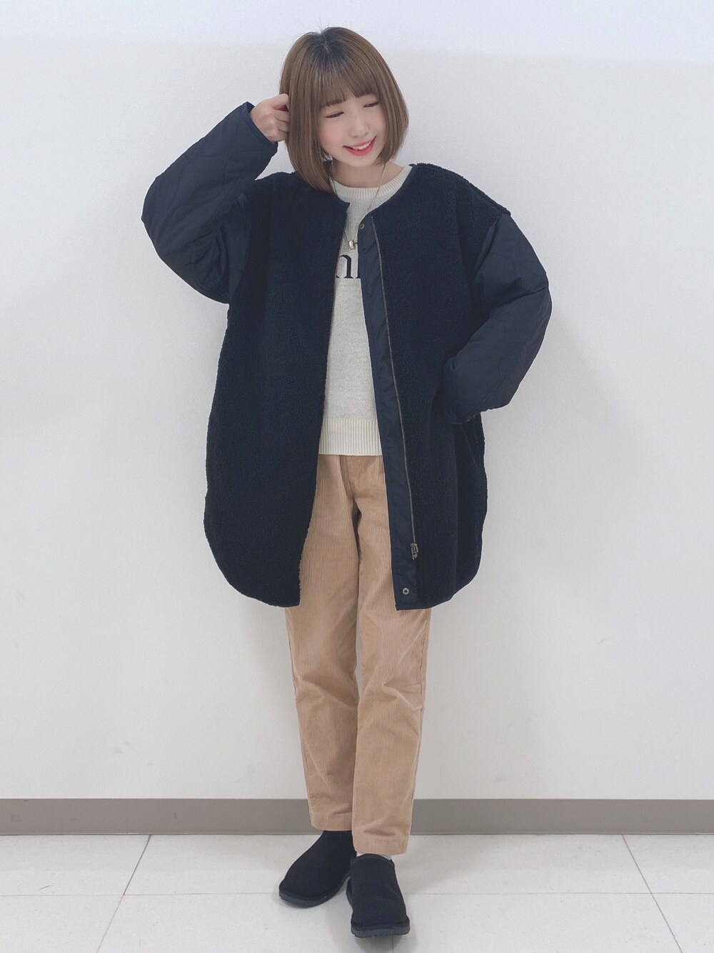 ブラック系のノーカラージャケット、ホワイト系のニット/セーター、イエロー系のその他パンツを着用したレディースの秋コーディネートの1枚目の写真