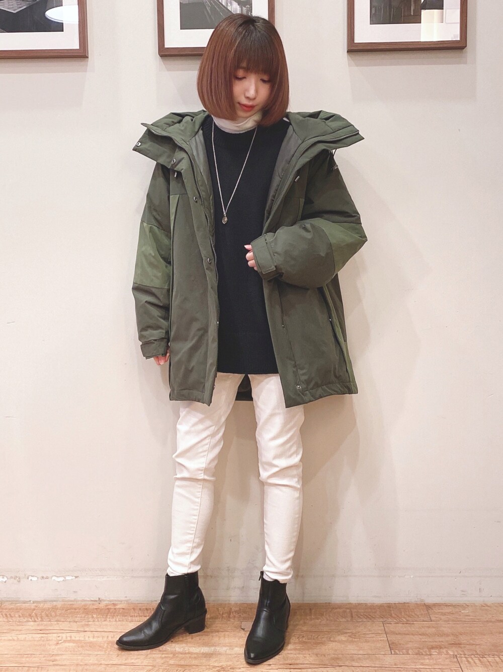 グリーン系のその他アウター、ブラック系のニット/セーター、ホワイト系のデニムパンツを着用したレディースの冬コーディネートの1枚目の写真