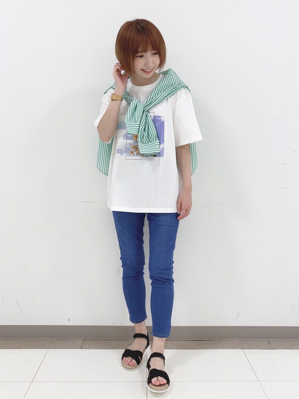 グリーン系のシャツ/ブラウス、ホワイト系のTシャツ/カットソー、ブルー系のデニムパンツを着用したレディースの春コーディネートの1枚目の写真