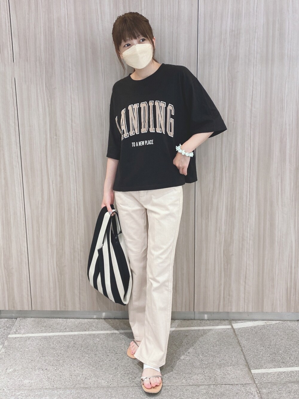 ブラック系のTシャツ/カットソー、ベージュ系のデニムパンツ、ベージュ系のサンダルを着用したレディースの夏コーディネートの1枚目の写真