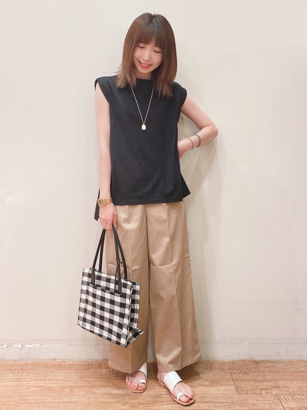 ブラック系のTシャツ/カットソー、ベージュ系のその他パンツ、ホワイト系のサンダルを着用したレディースの夏コーディネートの1枚目の写真